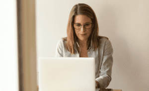 Womenwise women working on laptop with earbuds in